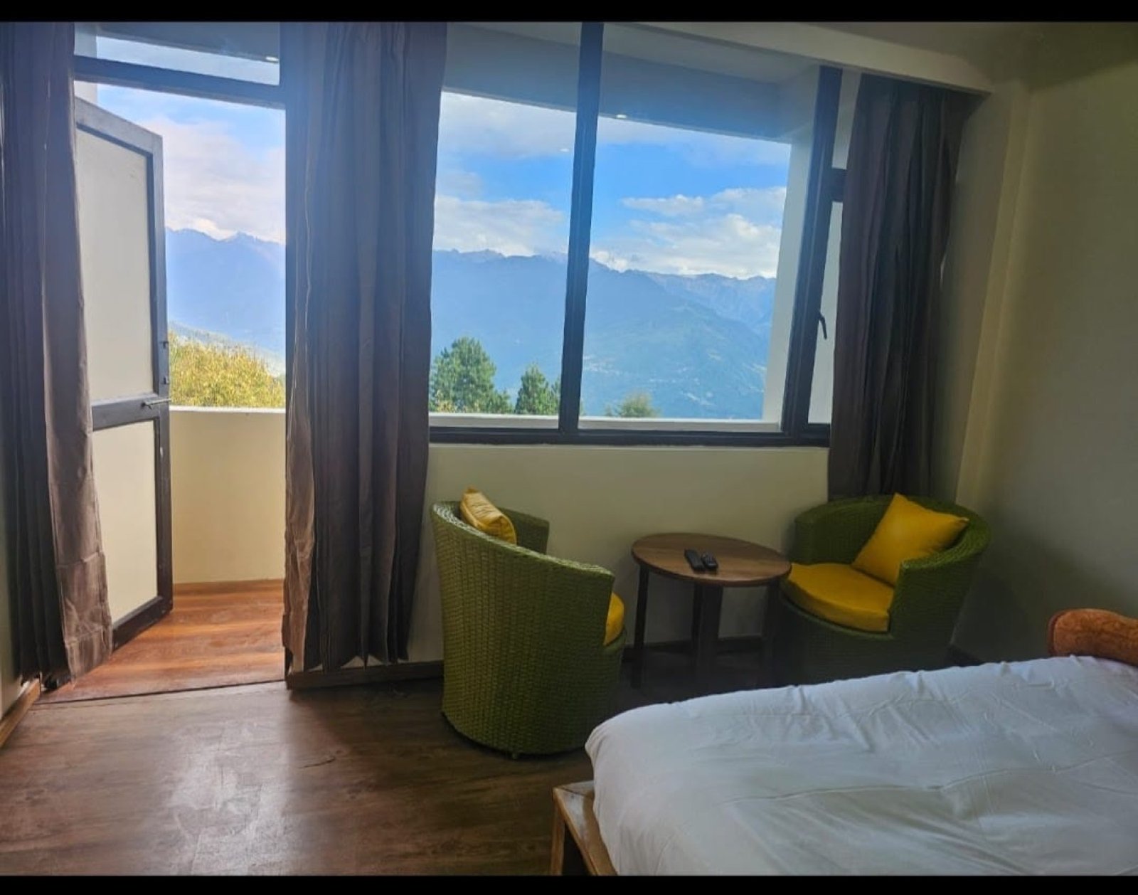 A Hotel Taktsang room with the balcony door open to the mountain view