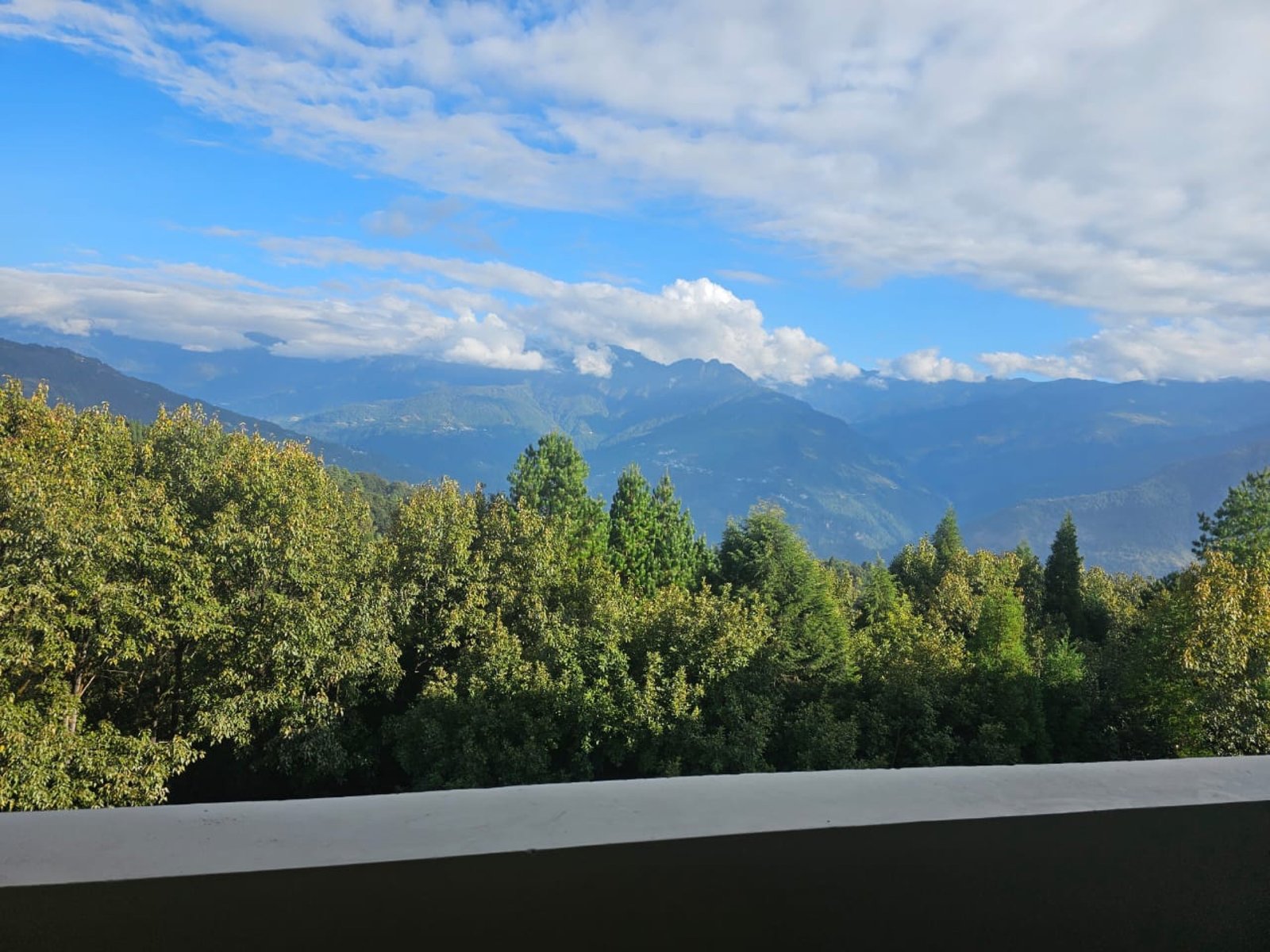 The view from a balcony at Hotel Taktsang &mdash; forest, cloud and distant ridges