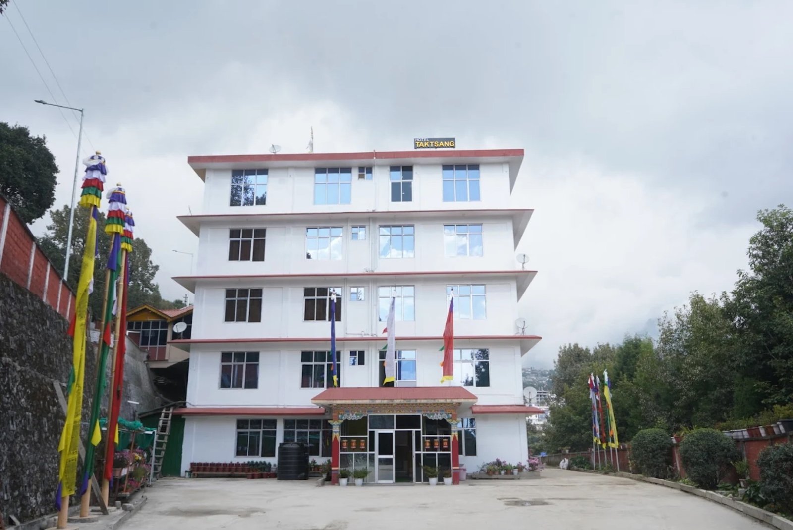 Hotel Taktsang &mdash; the white five-storey building above Tembrow with ceremonial flags