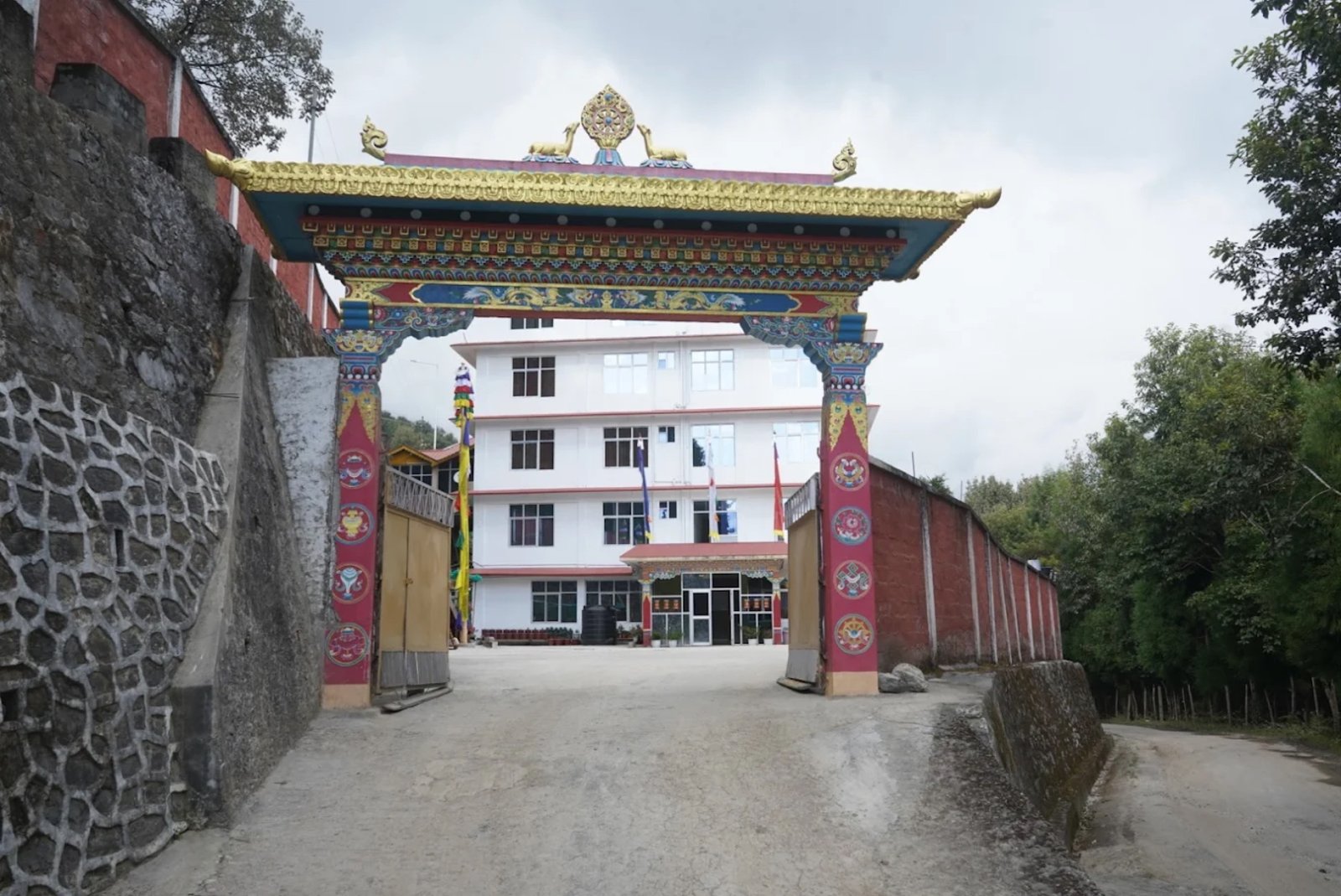 The painted ceremonial gate at Hotel Taktsang &mdash; dragons, lotus motifs, and the hotel beyond