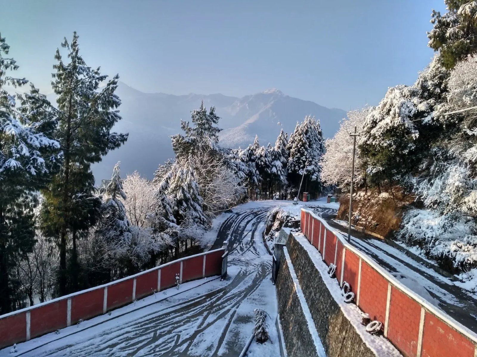 The road to Hotel Taktsang in winter &mdash; snow, prayer flags, and frost-tipped pines