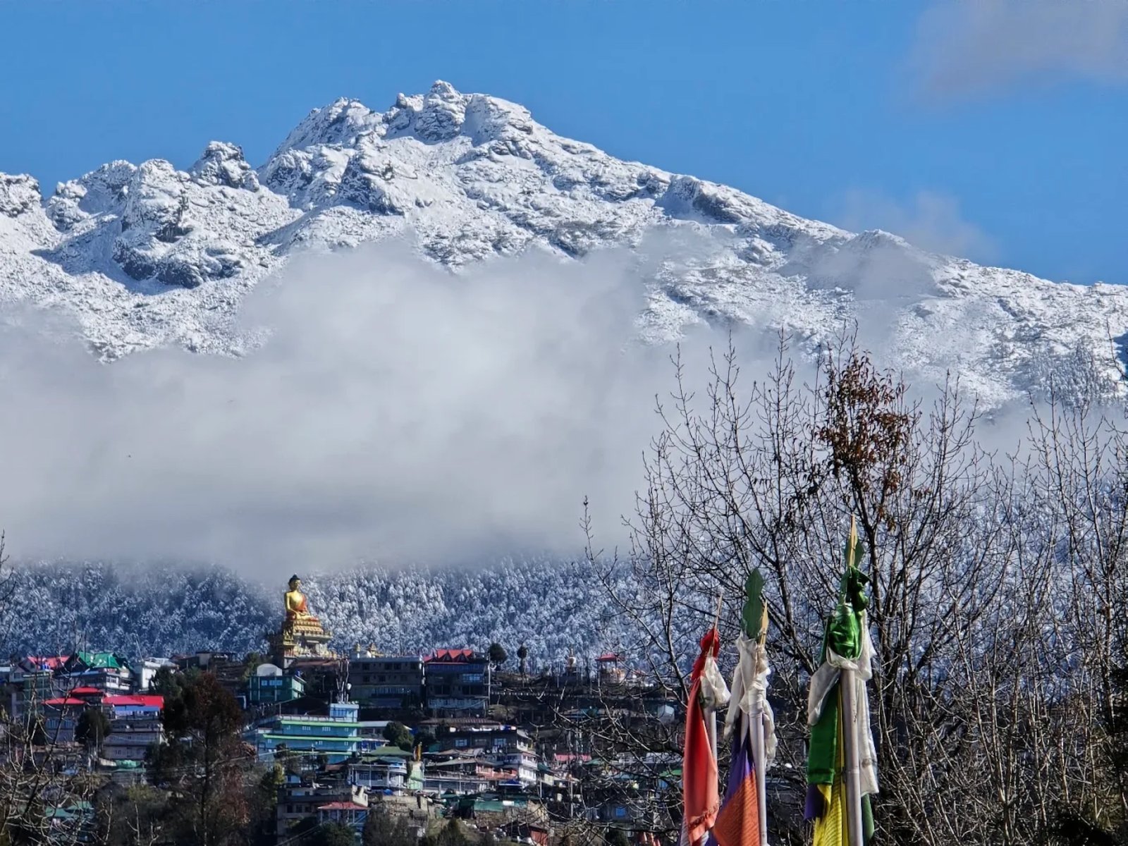 A snow-capped Himalayan ridge above Tawang, with prayer flags in the foreground