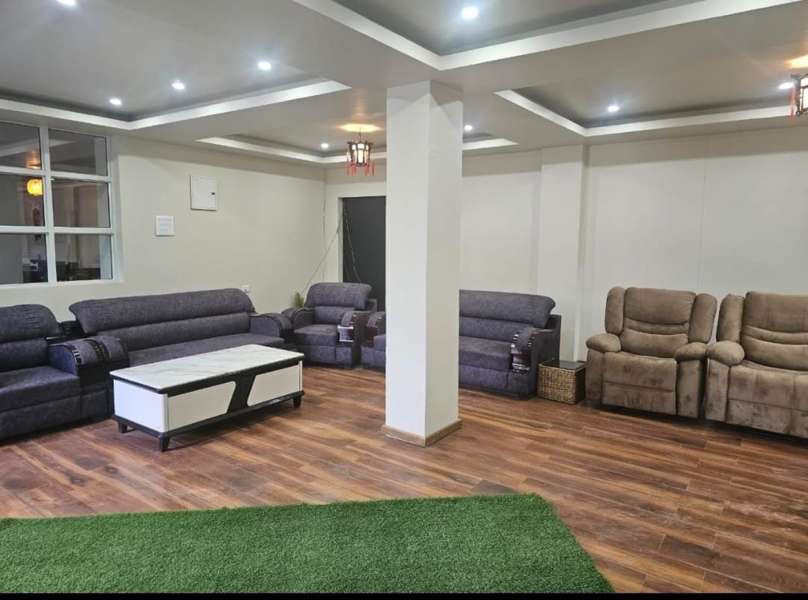 The guest lounge at Hotel Taktsang &mdash; sofas, recliners, and a green carpet