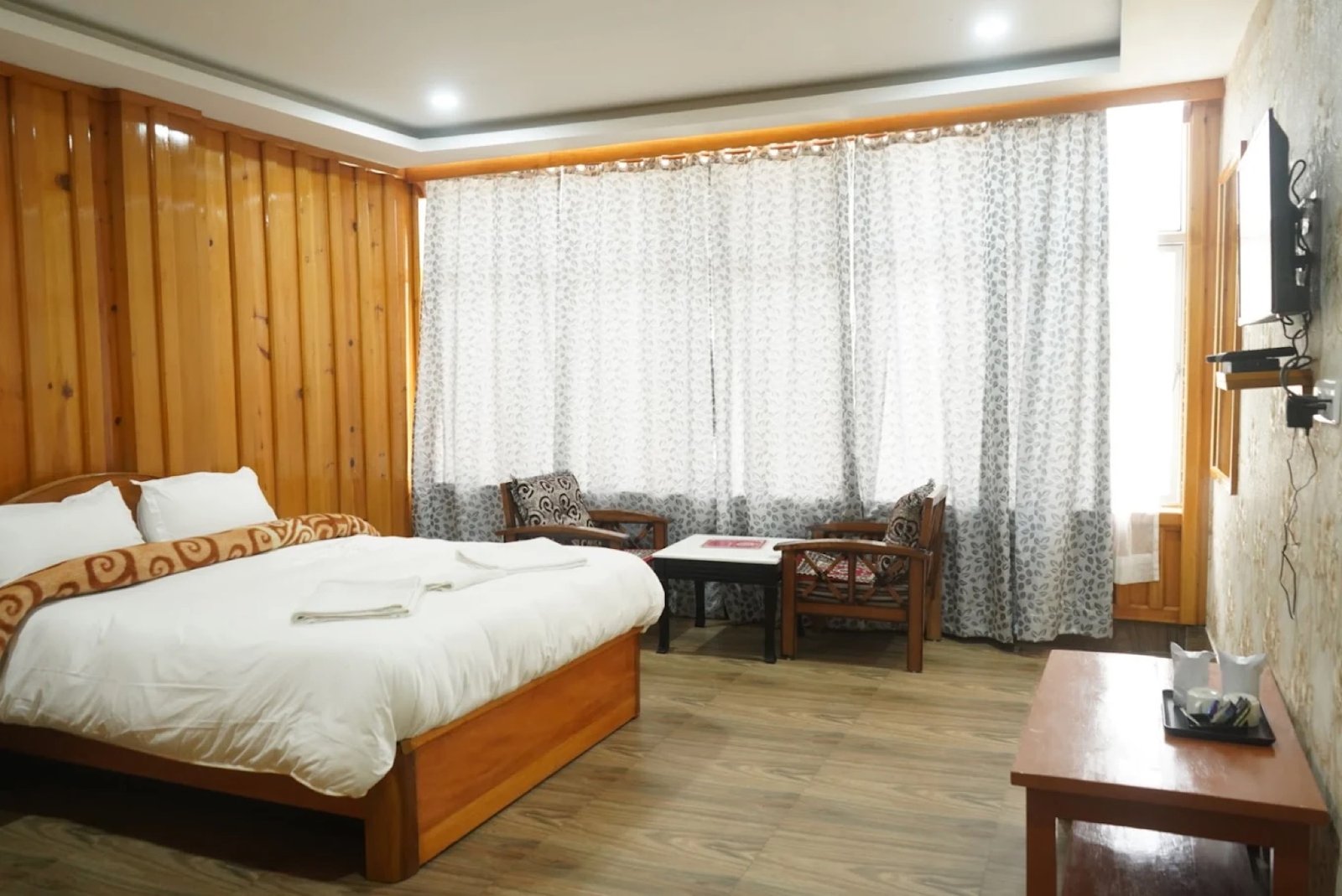 Premium Room at Hotel Taktsang &mdash; King bed, armchairs, and a wide Himalayan window