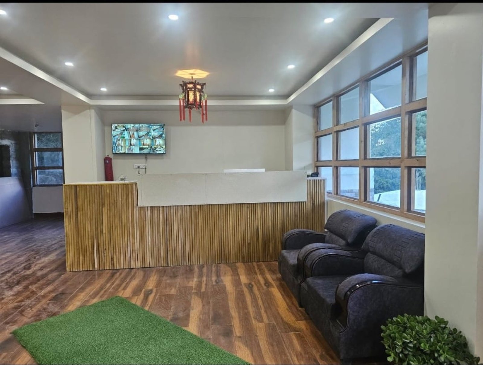 The reception desk at Hotel Taktsang &mdash; bamboo panelling, a Chinese lantern, and a grey sofa