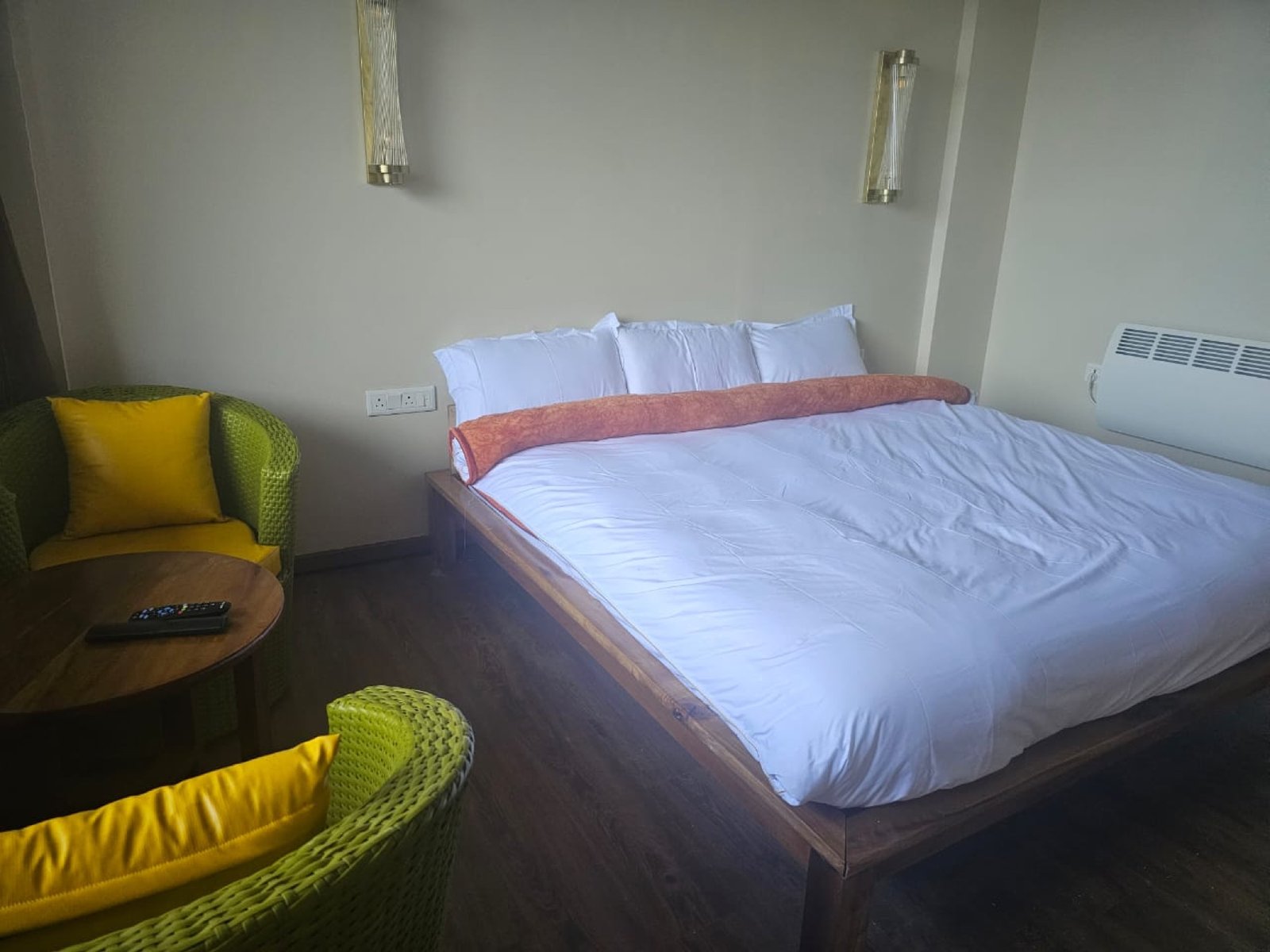 A King bed at Hotel Taktsang with a pair of brass reading sconces above