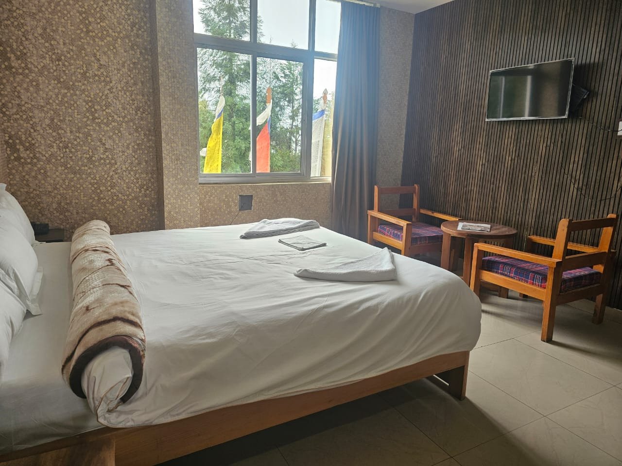 Super Deluxe Room at Hotel Taktsang &mdash; King bed, brass sconces, a window on the valley